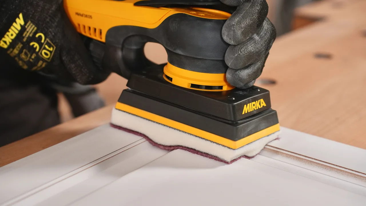 Mirka DEOS sander with the profile foam interface on a profiled panel